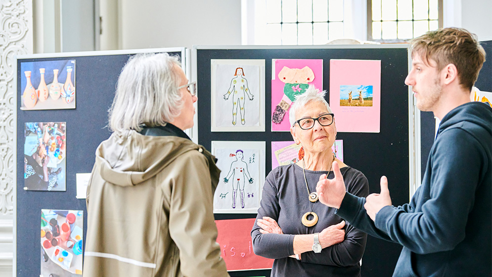 People chatting at an art exhibition